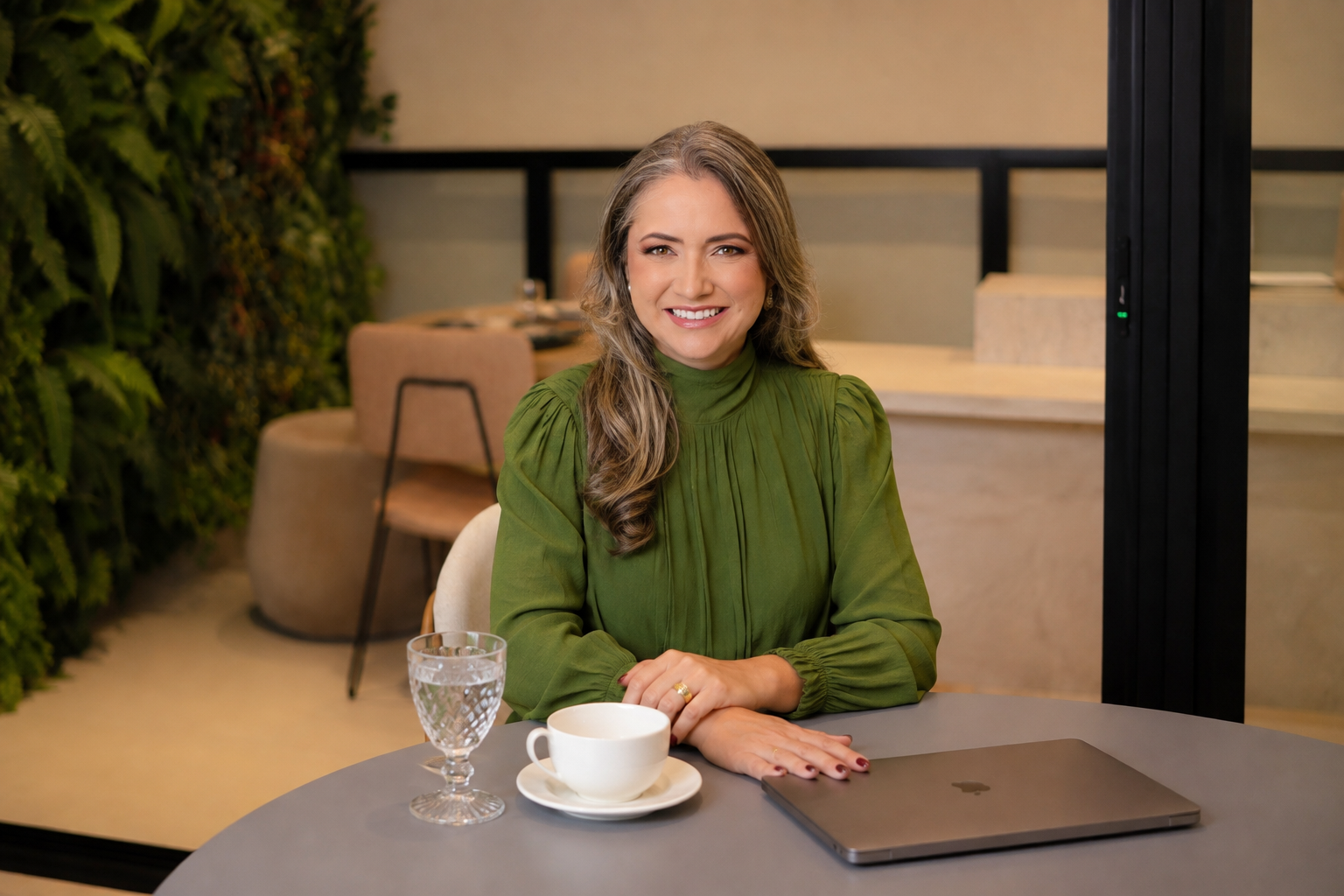 Rejane Duarte sentada à mesa em um ambiente de escuta reservado